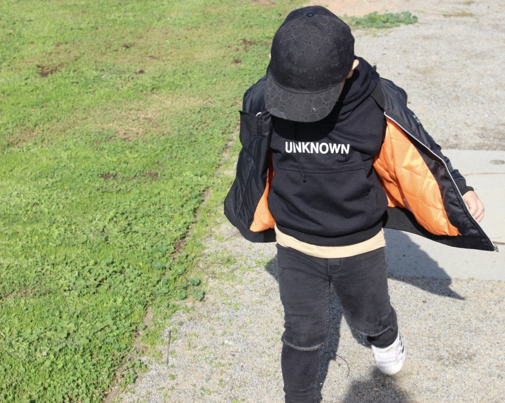 A trendy unisex kids bomber jacket styled for a fashionable look.