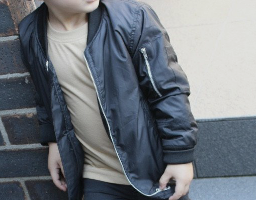 A trendy unisex kids bomber jacket styled for a fashionable look.