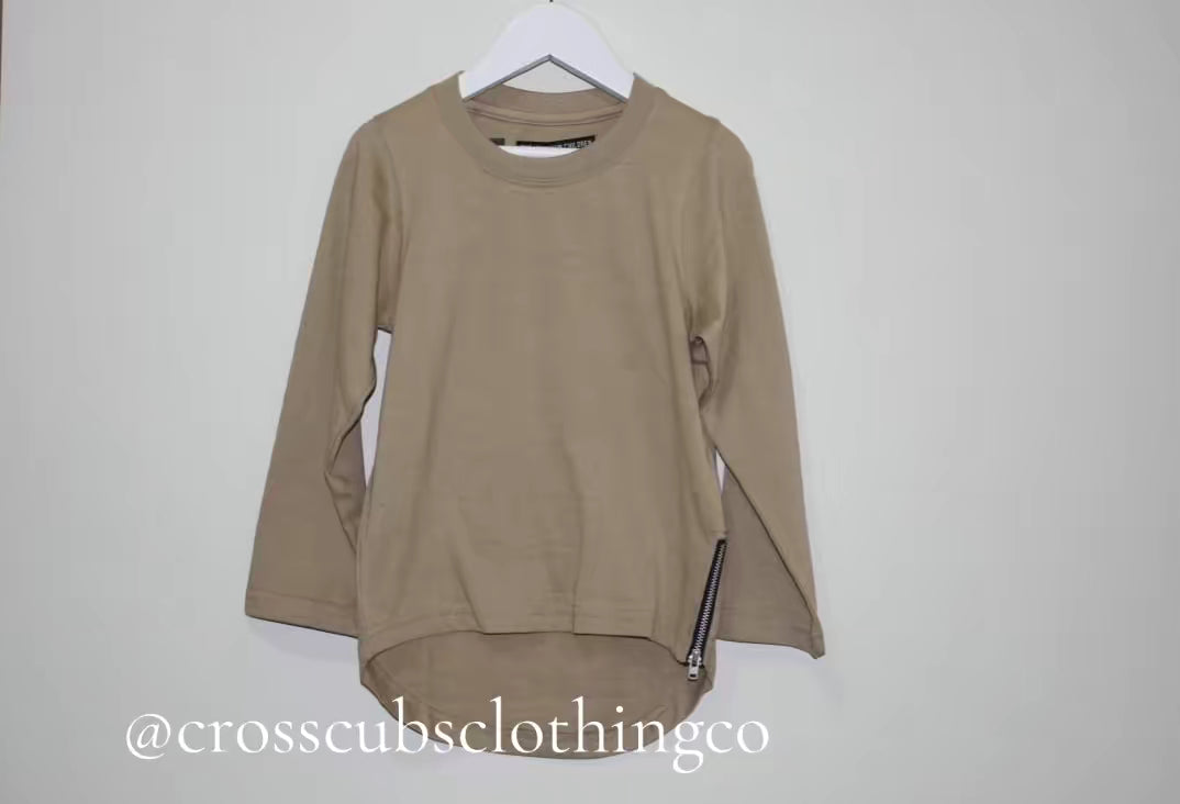 Beige long-sleeve curved hem t-shirt from THE UNKNOWN CHILDREN, featuring a side zipper detail. Made from 100% superior cotton for comfort and durability, this stylish tee is perfect for casual and everyday wear.