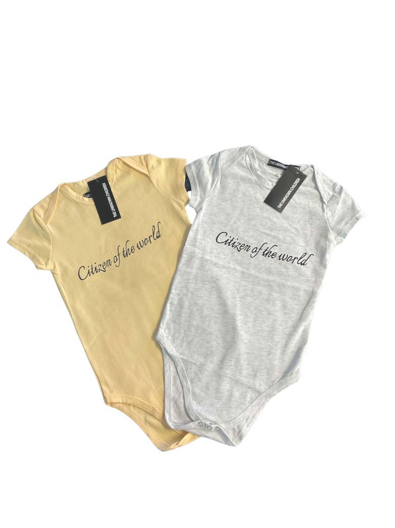 Two "Citizen of the World" onesies from THE UNKNOWN CHILDREN in soft yellow 
and light gray, made from 100% breathable cotton, displayed with branded tags. 
Perfect for active toddlers with comfort and style.